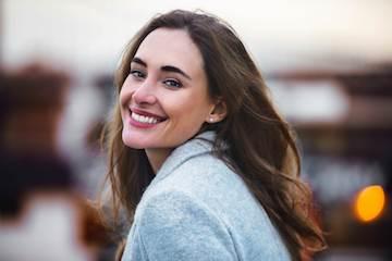 woman smiling looking behind her shoulder