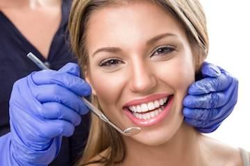 woman smiling while getting a dental exam