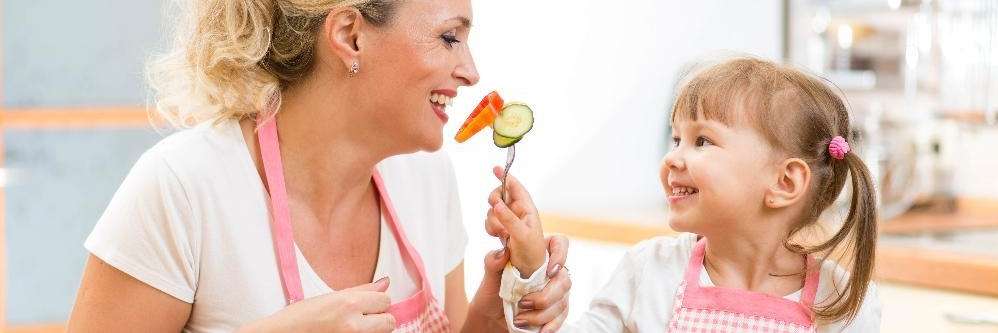 Daughter offering her mother healthy foods for her teeth