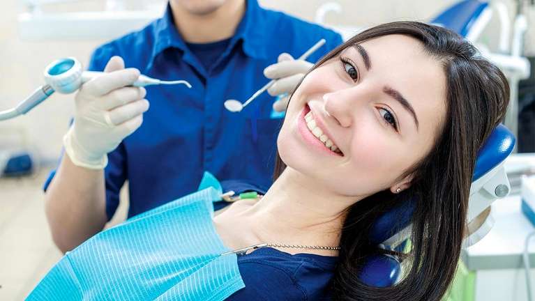 Woman smiling during a dental exam | Dentist Gaithersburg, MD